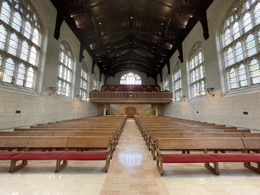 Inside of Graham Chapel, view of wood and red pews