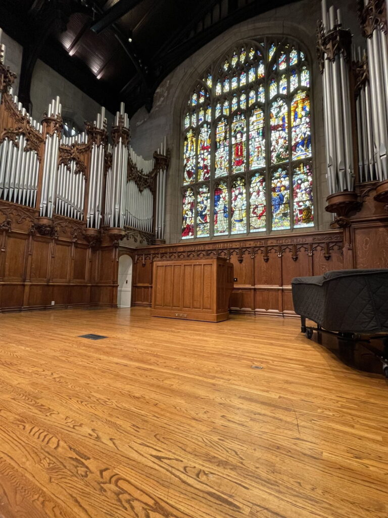 Inside of Graham Chapel, view of stained glass window and organ pipes