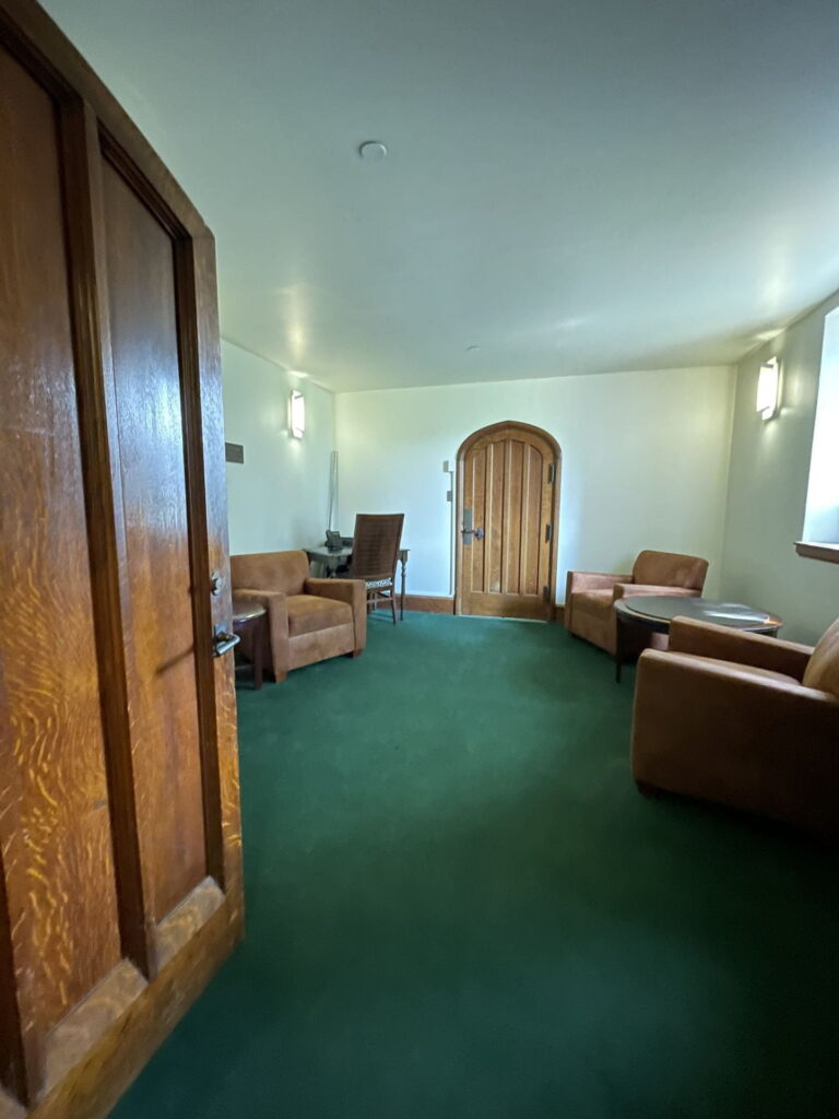 Inside of Graham Chapel, view of "staging" area with wood doors and green carpet