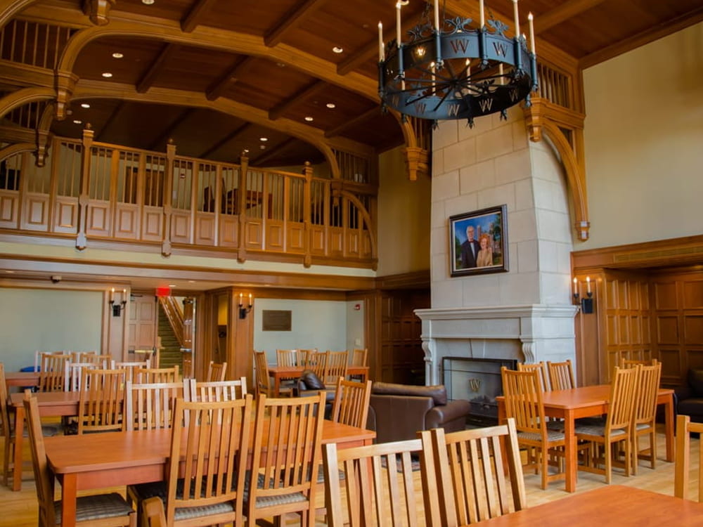 Image of Lopata House Great Hall. A large room with wooden accents and a fireplace.