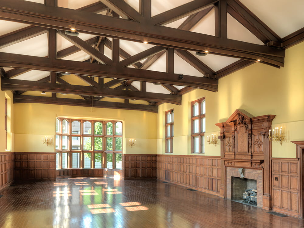 Photo of large conference style room with wood paneling and beams.